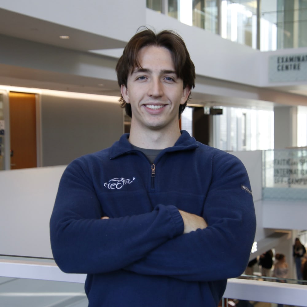 Matteo Ruzdijic smiling with arms crossed, wearing a navy Relectric fleece